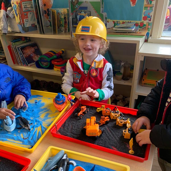 little boy playing with toy trucks